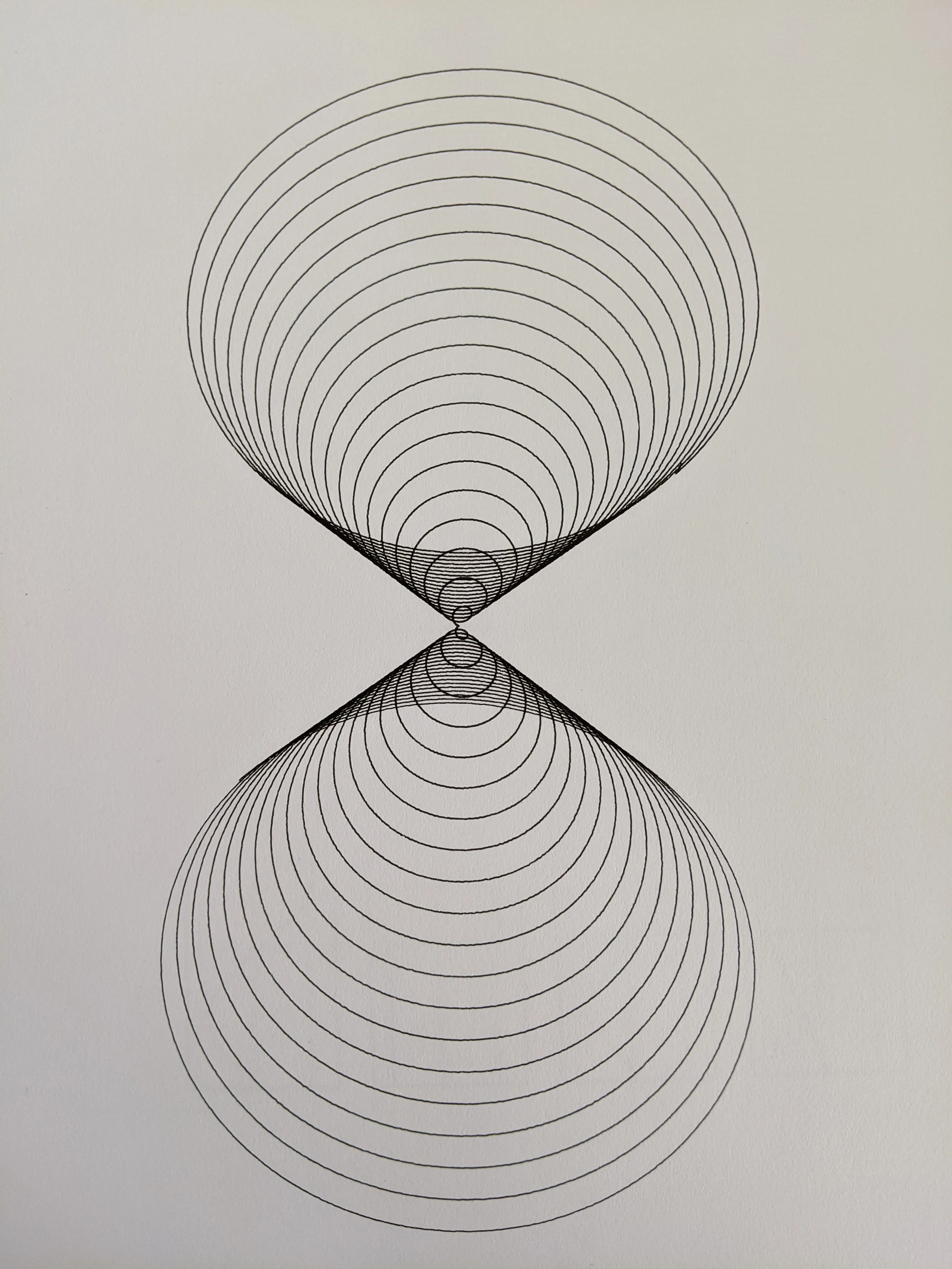 Two teardrop clusters of concentric circles meeting point to point in an hourglass on white paper